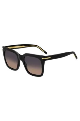 Gafas de sol de acetato negro con detalles metálicos dorados